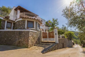 A two-story house with a stone facade, a balcony with a metal railing, and a gated entrance. - Seaview Luxury Villa with terrace, gym, jacuzzi, pool & bbq (Massa Lubrense)