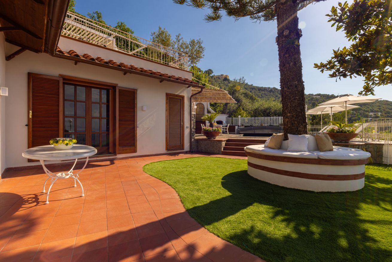 Una villa con un patio, una zona de estar circular y vistas del paisaje circundante.