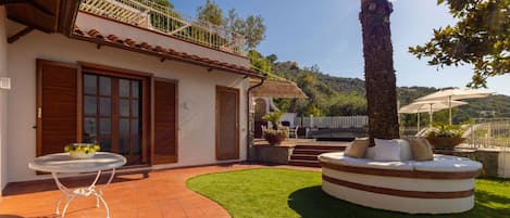 Une villa dotée d’un patio, d’un espace salon circulaire et offrant une vue sur le paysage environnant.