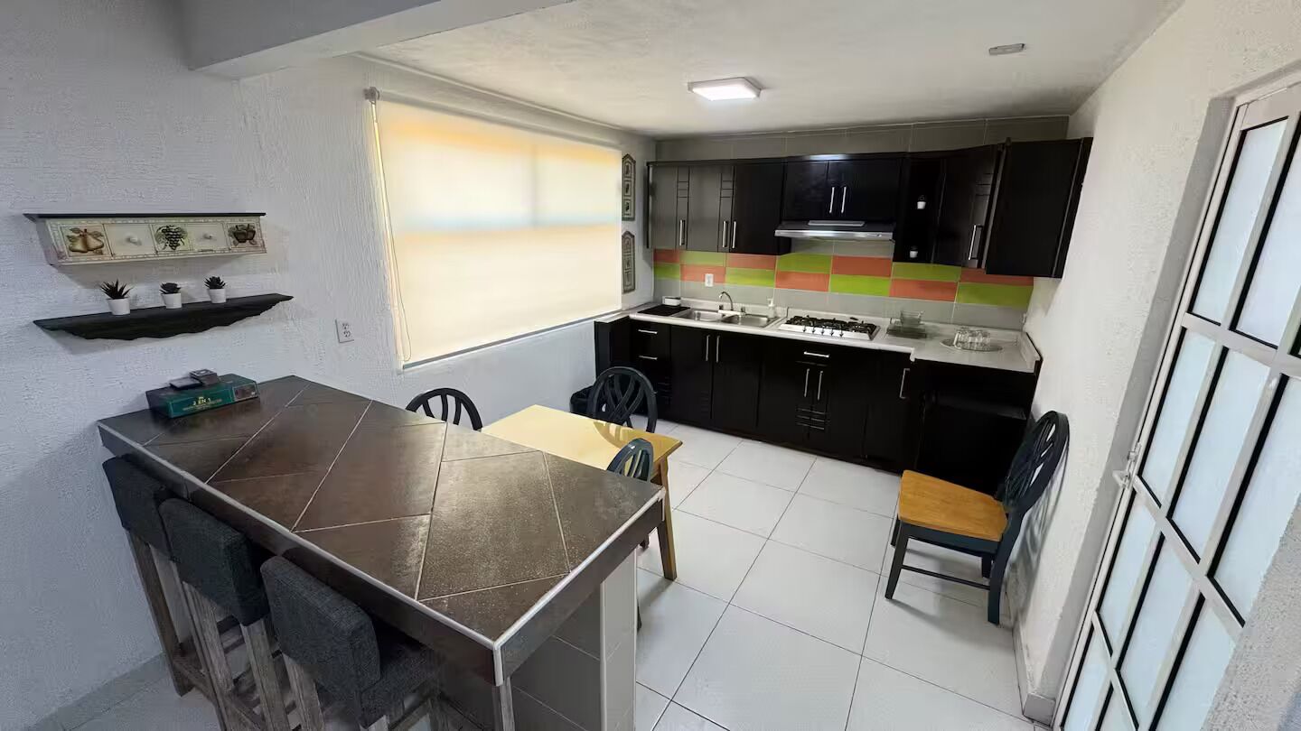 Kjøleskap, kjøkkenutstyr, spisebord og kjøkkenøyer