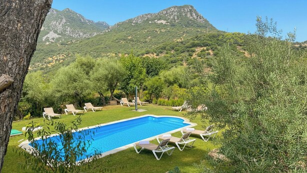 Une piscine avec des chaises longues et une vue imprenable sur les montagnes.