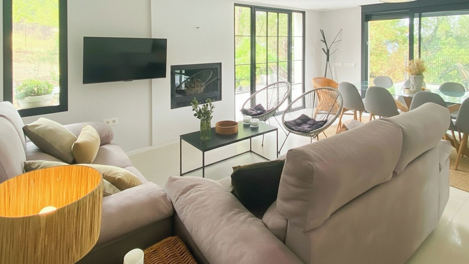 Ein modernes Wohnzimmer mit einer Couch, einem Couchtisch und einem an der Wand befestigten Fernseher.