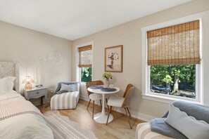 Un dormitorio con cama, mesita de noche, lámpara y ventana con persianas.