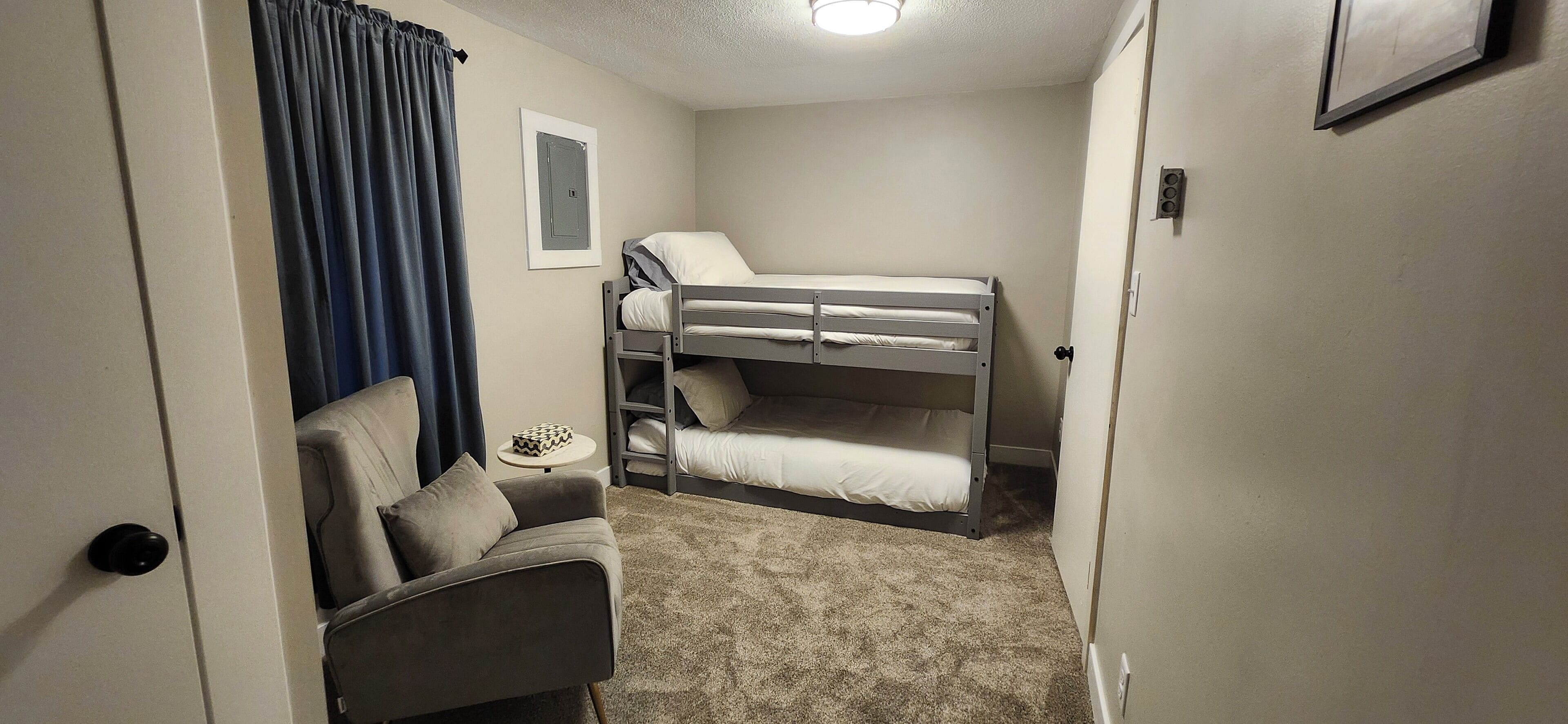 A small, compact room with bunk beds, a sofa, and a small table.