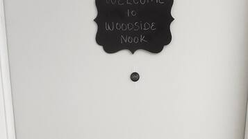 Una porta con un cartello nero che riporta la scritta “Welcome to Woodside Book”.