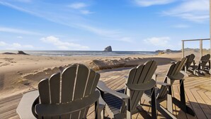 Una terraza frente al mar con sillas Adirondack.
