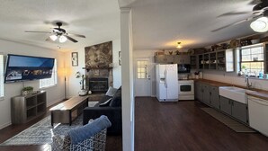 A spacious living room with a fireplace, a TV mounted on the wall, and a cozy seating area. - Farm Stay Near Town - Animals, Fire Pit, & Privacy - close to wedding venues (Georgetown)