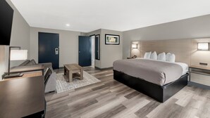 A modern hotel room with a bed, desk, chair, and a television. - Red Lion Inn & Suites Kansas City (Kansas City)