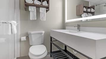 Une salle de bain moderne équipée de toilettes, d’un lavabo, d’une douche et d’un porte-serviettes.