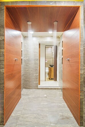 Un baño moderno con zona de ducha, inodoro y lavabo.