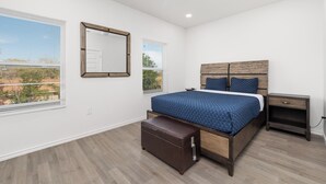 Camera da letto con un letto, un comodino, una panca e una ventola a soffitto.