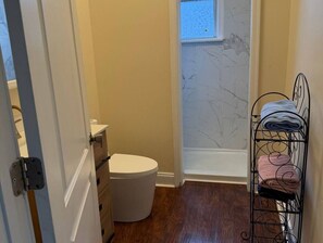 Ein Badezimmer mit Toilette, Waschbecken, Handtuchhalter und einem Fenster.