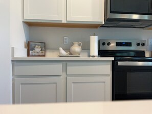 A kitchen with white cabinets, a stainless steel oven, and a microwave. - Fresh & Spacious 4BR in Port Saint Lucie (Port St. Lucie)