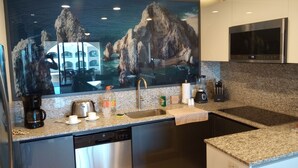 Una cocina moderna con encimeras de granito, electrodomésticos de acero inoxidable y una isla grande.