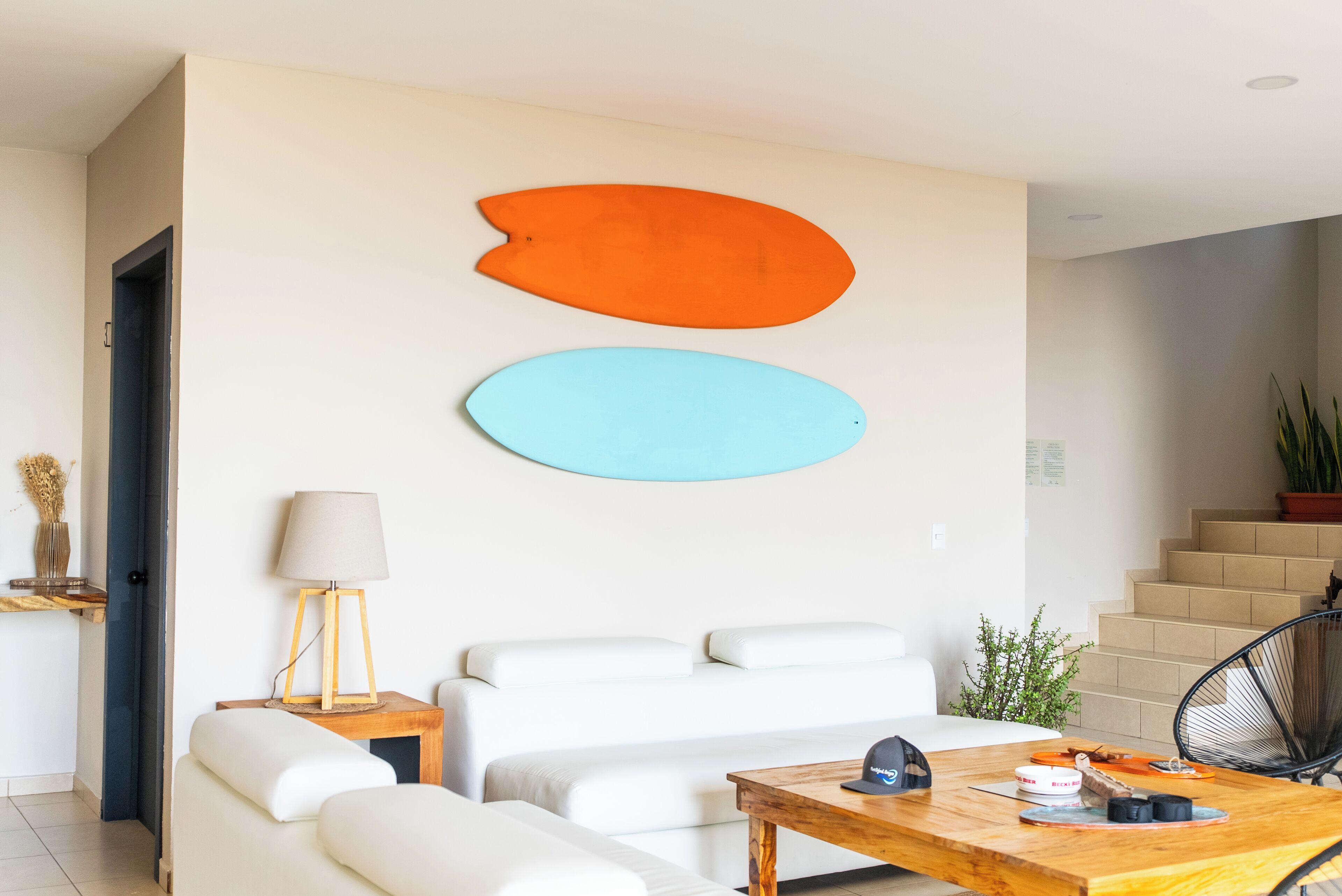 Una sala de estar moderna con un juego de sofá, una mesa de centro de madera y dos obras de arte abstracto colgadas en la pared.