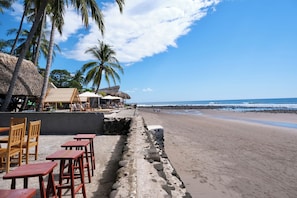 En la playa, arena negra, masajes en la playa, yoga en la playa