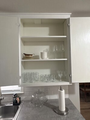 A kitchen with a white cabinet, a sink, and a countertop.