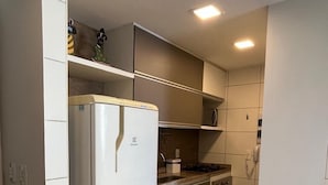 Una cocina compacta equipada con refrigerador, estufa y pileta.