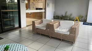 Una cafetería con temática de playa, con mobiliario de mimbre y piso de baldosas.