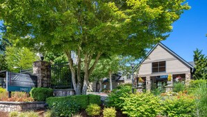 A residential property with a stone entrance, a well-maintained garden, and a house with a pitched roof and multiple windows. - A Cozy 1-bedroom apartment in serene Everett with fitness room is available. (Everett)