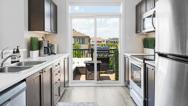 Une cuisine moderne avec une porte-fenêtre coulissante donnant sur un patio.