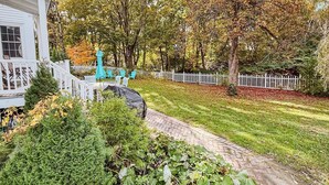 A white house with a covered porch, a brick pathway, and a white picket fence. - Charming Historic home steps away from downtown (Bath)