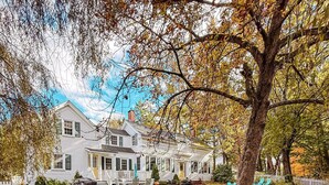 A two-story white house with a porch and a lawn with fallen leaves. - Charming Historic home steps away from downtown (Bath)