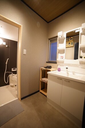 A compact bathroom with a shower, a vanity with a mirror, and a small window. - Route 99 Miyagino (Hakone)