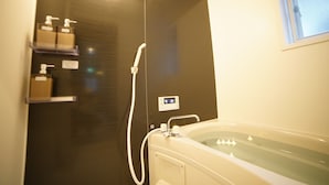 A modern bathroom with a bathtub, a shower, and a hand dryer. - Route 99 Miyagino (Hakone)