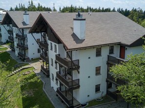 A multi-story building with balconies and a sloped roof. - Whistlepunk #43: 1 bedroom with Loft, Slopeside (Snowshoe)