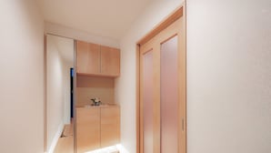 Ein schmaler Flur mit einem Holzschrank und einem kleinen Tisch mit einer Vase.