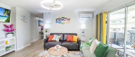Uma sala de estar moderna com um sofá, uma mesa de centro e vista para a varanda.