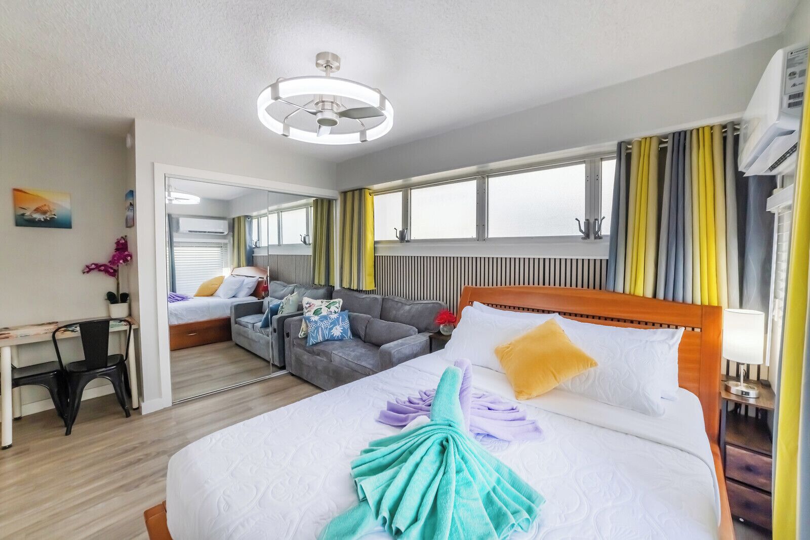 Une chambre d’hôtel avec un lit, un canapé, un bureau et un miroir.