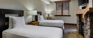 A hotel room with two beds, a TV, a fireplace, and a window with blinds. - Spacious 2-Bedroom Deluxe Condo in Magical Park City (Park City)