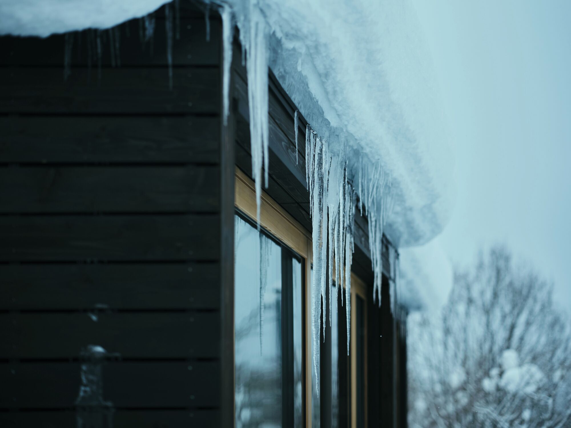 A wooden building with icicles hanging from the roof.
