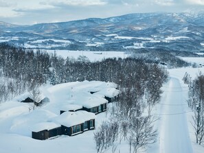 A snow-covered landscape with a road and buildings. - SANU 2nd Home Niseko 1st (Niseko)