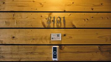 A wooden wall with the number 8101, a QR code, and a digital lock.