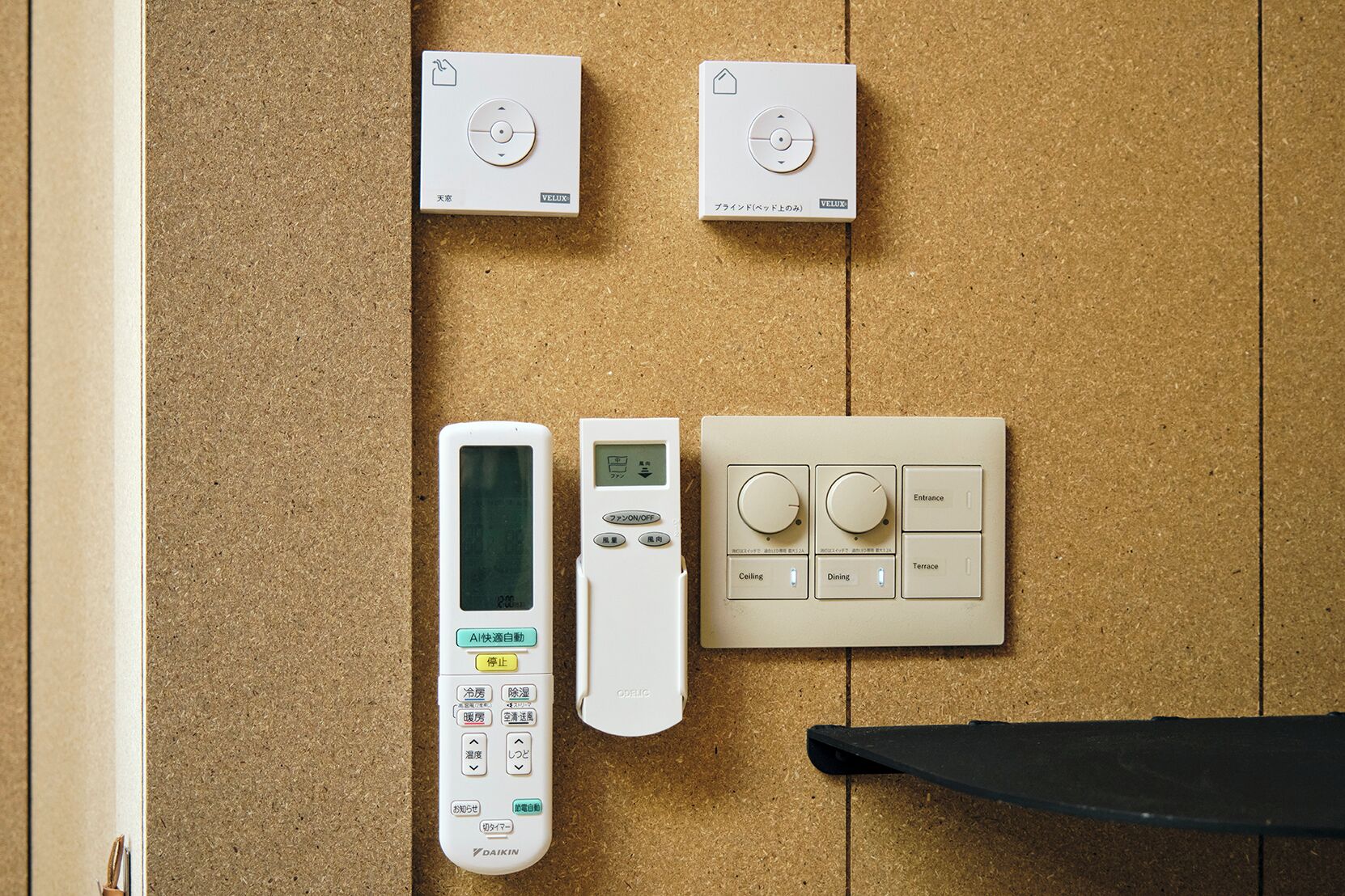 Un panel de control con un control remoto, dos dispositivos de pared y un termostato.