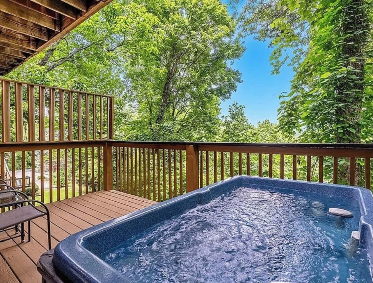 Un bain à remous sur une terrasse en bois, avec vue sur les arbres.