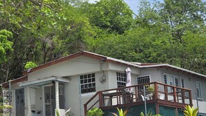 A two-story house with a fenced front yard, a covered porch, and a staircase leading to the upper floor.