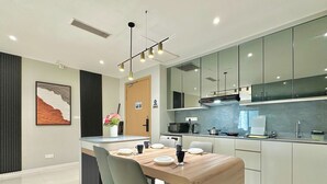 Una cocina moderna con una isla central, un comedor con mesa y sillas, y un espejo grande sobre la encimera.