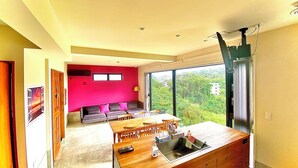 Una cocina moderna con una isla grande, un comedor y vistas a zonas verdes.