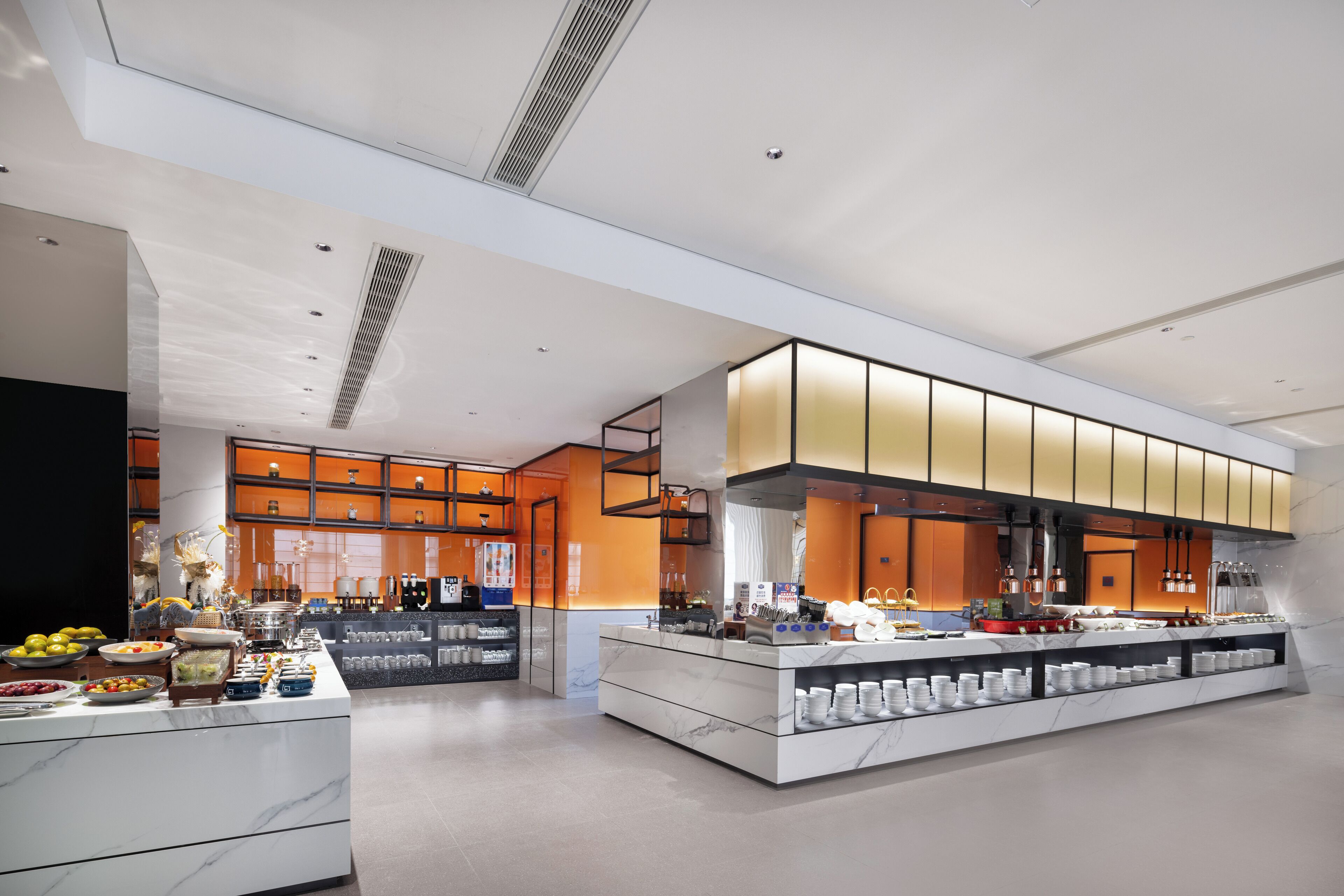 Un hall d’hôtel moderne, doté d’un aménagement spacieux, d’un comptoir d’accueil central et d’un buffet.