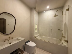 Uma casa de banho moderna com sanita, lavatório e cabine de duche com vidro.