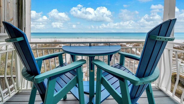 Un espacio de estar techado al aire libre con vista a la playa.