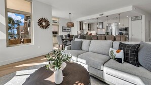 Una sala de estar moderna con un sofá gris, una mesa de centro y un ventanal grande.