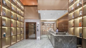 Eine Hotelhalle mit Marmorboden, einer Rezeption und Regalen mit verschiedenen Dekorationselementen.