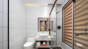 Ein modernes Badezimmer mit Toilette, Waschbecken und Duschbereich.
