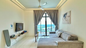 A living room with a sofa, a TV, a ceiling fan, and a large window with curtains. - The Platino Paradigm Mall by Stayrene (Johor Bahru)
