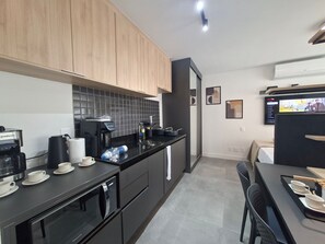 Eine moderne Küche mit Kaffeemaschine, Wasserkocher und Toaster. Ein Essbereich mit Tisch und Stühlen ist ebenfalls vorhanden.